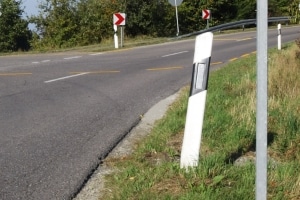 Orientieren Sie sich an einem Begrenzungspfeiler um zu prüfen, ob Sie den Sicherheitsabstand auf der Landstraße einhalten.