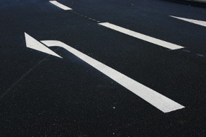 Markierungen sind eine Kategorie der Verkehrszeichen. Pfeilmarkierungen geben z. B. die Fahrtrichtung an.